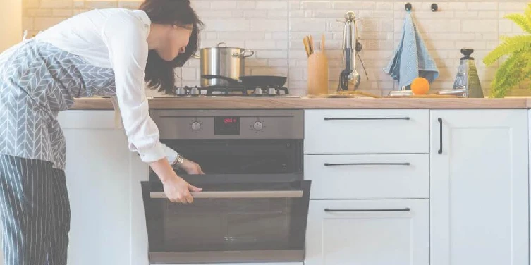 Young woman looking at oven