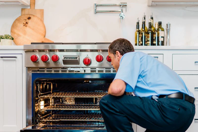 Mr. Appliance repairman inspecting an oven 