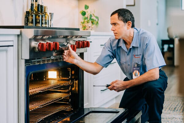 Mr. Appliance technician repairing an oven