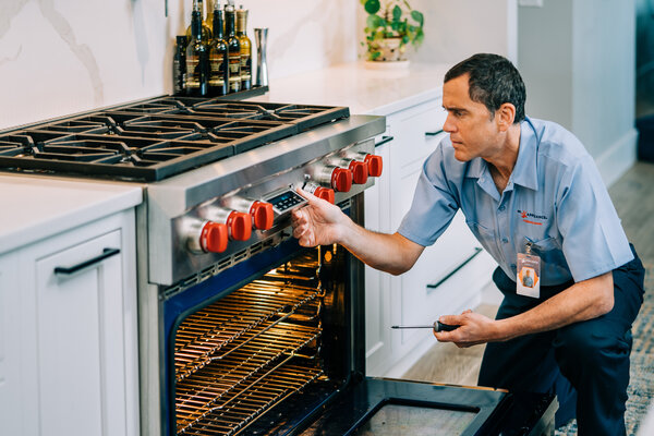 A Mr. Appliance oven repairman troubleshooting a high-end range