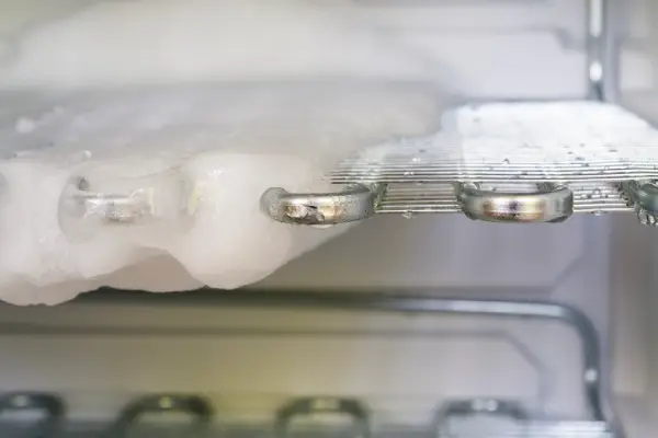 Ice buildup on a freezer rack before the freezer defrosting process.