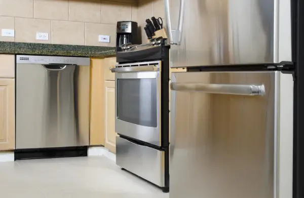 Kitchen with stainless steel appliances and light brown wooden cabinets.