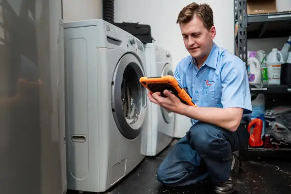 A Mr. Appliance service professional inspecting a dryer that won’t spin.