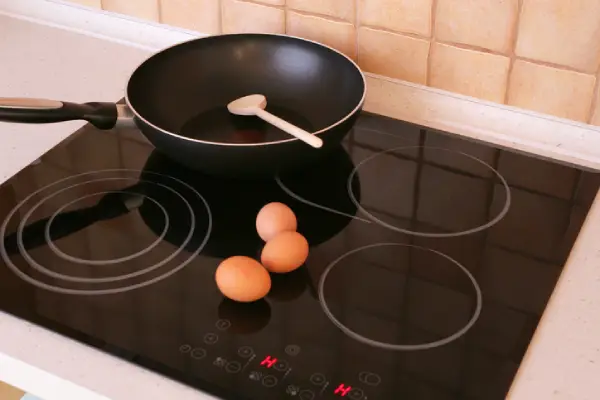 Pan and eggs on a hot glass top stove.